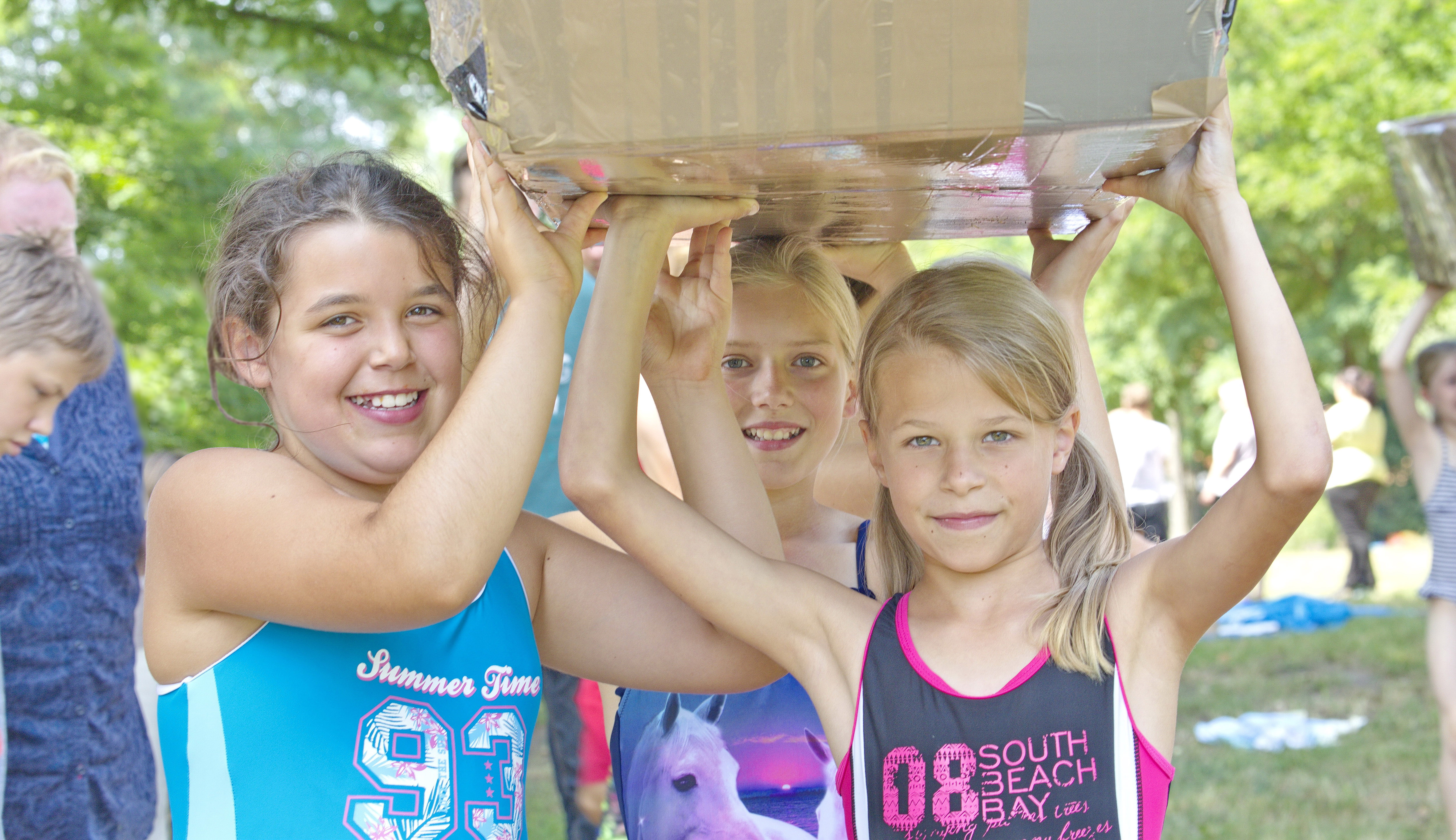 Bild mit Mädchen, die ein selbstgebautes Boot tragen